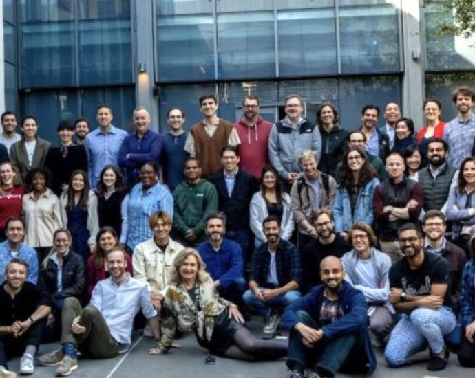 AI science funding - Scientists working with AI technology in a modern research laboratory