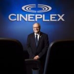 Canadian film box office - Interior view of a modern movie theatre with rows of red seats facing a large screen