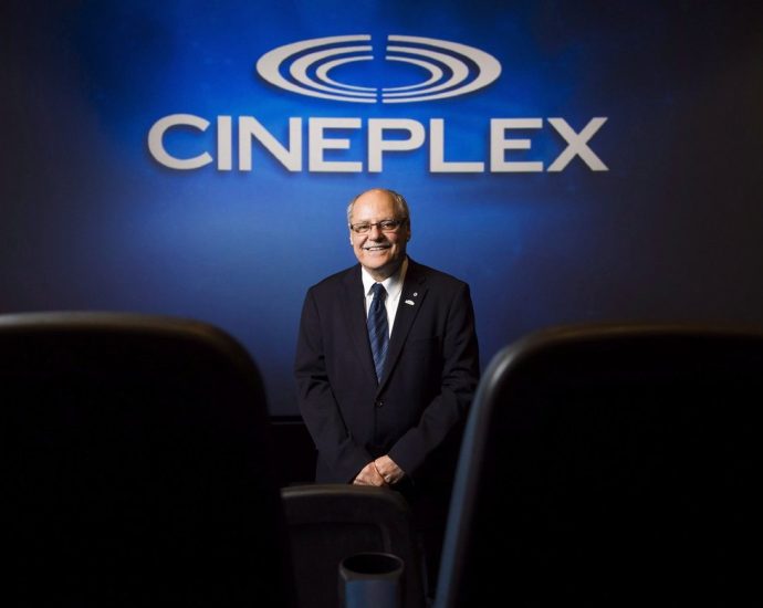 Canadian film box office - Interior view of a modern movie theatre with rows of red seats facing a large screen