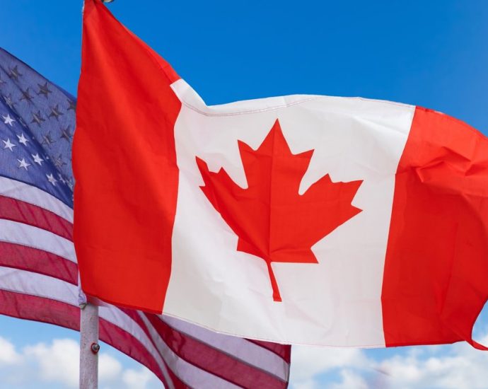 Canadians visiting US - Cars lined up at a Canada-US border crossing with customs booths visible