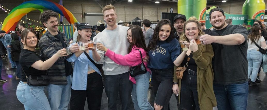 Edmonton Craft Beer Festival - People sampling craft beer at a large indoor festival with multiple brewery booths and tasting stations