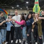 Edmonton Craft Beer Festival - People sampling craft beer at a large indoor festival with multiple brewery booths and tasting stations