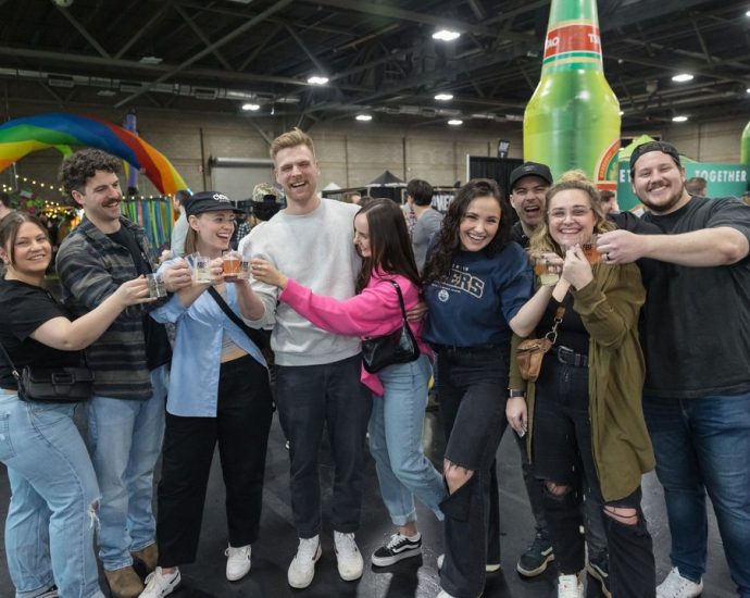 Edmonton Craft Beer Festival - People sampling craft beer at a large indoor festival with multiple brewery booths and tasting stations