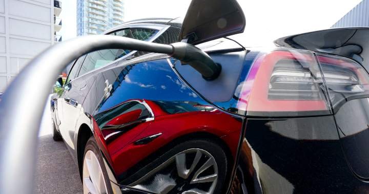 EV rebates charging costs - Electric vehicle plugged into charging station with power cable connected