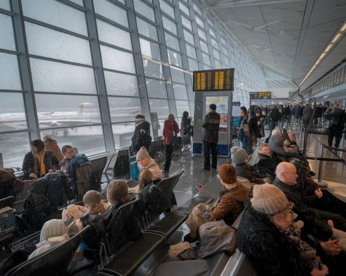 flight delays Canada - Snow-covered aircraft and airport runway during winter storm causing flight delays