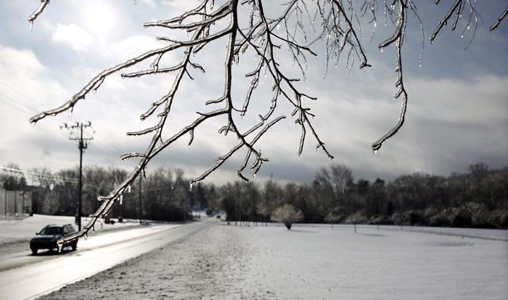 freezing drizzle advisory - Ice-covered road in Toronto during winter storm with cars driving cautiously