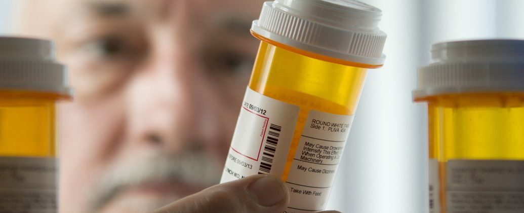 national pharmacare program - Pharmacist dispensing prescription medications at pharmacy counter