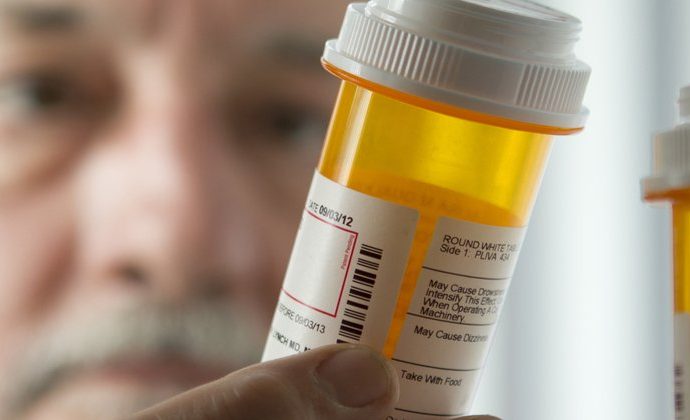national pharmacare program - Pharmacist dispensing prescription medications at pharmacy counter