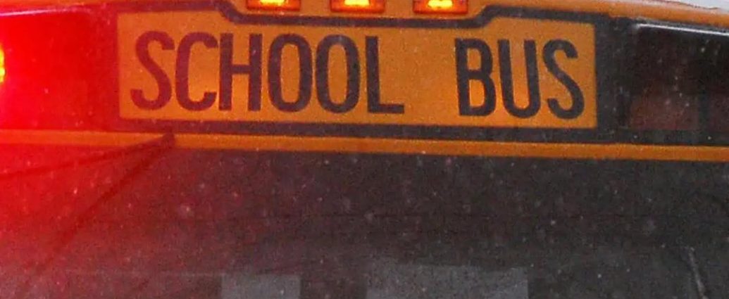 school bus crash - School bus on snowy winter road with emergency vehicles responding to accident scene
