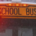 school bus crash - School bus on snowy winter road with emergency vehicles responding to accident scene