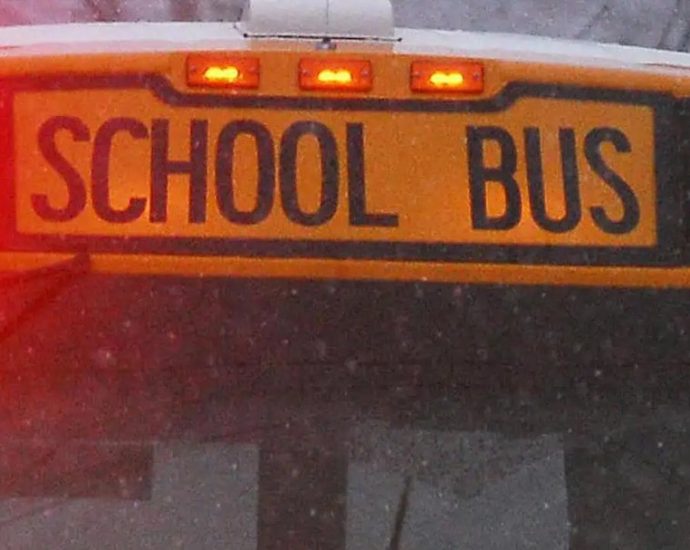 school bus crash - School bus on snowy winter road with emergency vehicles responding to accident scene