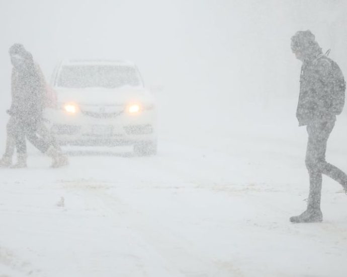 Snowy road conditions during Toronto winter storm with heavy traffic and poor visibility