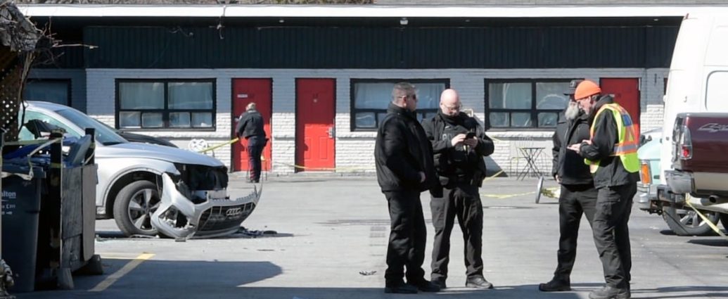Burlington police shooting - Police vehicles and investigators at crime scene with yellow tape