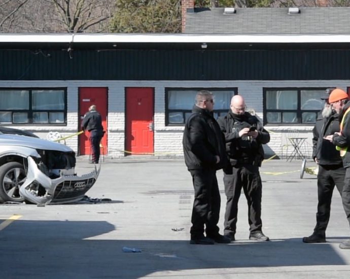 Burlington police shooting - Police vehicles and investigators at crime scene with yellow tape