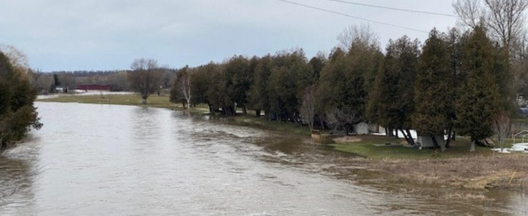 flood warning Ontario - Flooded river with warning signs in southwestern Ontario community