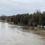 flood warning Ontario - Flooded river with warning signs in southwestern Ontario community