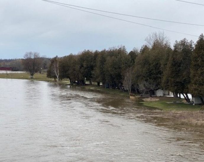 flood warning Ontario - Flooded river with warning signs in southwestern Ontario community