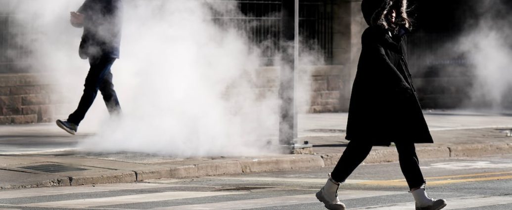 GTHA wind chill warning - Person bundled up walking in extreme cold weather with visible breath in winter conditions