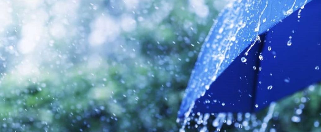 rainfall warning Ottawa - Heavy rain falling on a road with water pooling and cars driving through flooded conditions