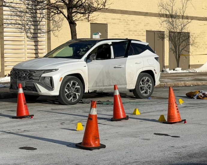 Toronto police shootings - Police officers investigating a crime scene with evidence markers