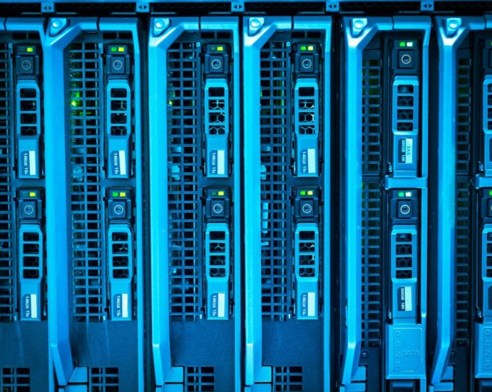 California datacenter ban - Rows of server racks inside a large data centre with blue indicator lights